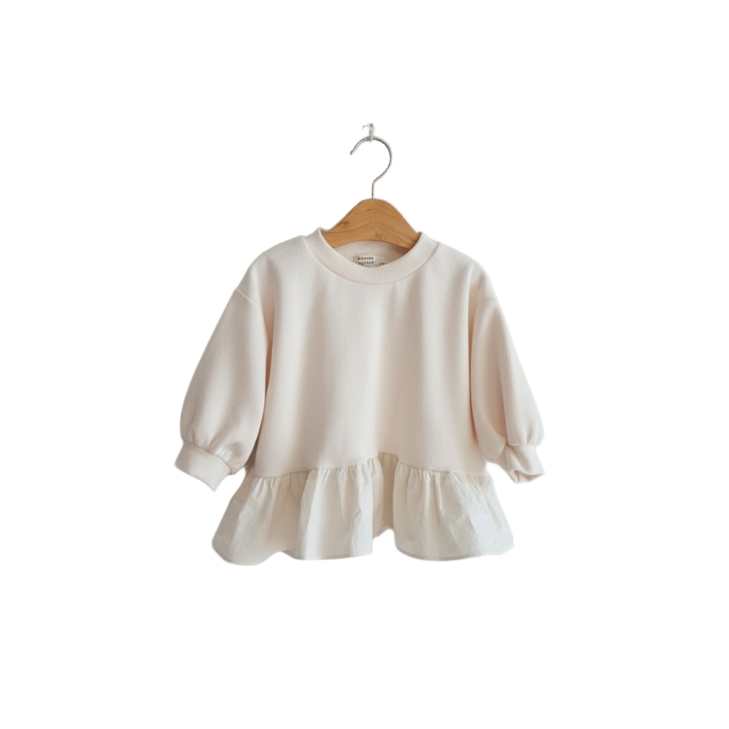 Beige sweater with ruffled hem on a wooden hanger against a white background