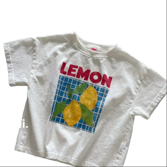 White t-shirt with 'LEMON' and lemon graphic on a light gray background