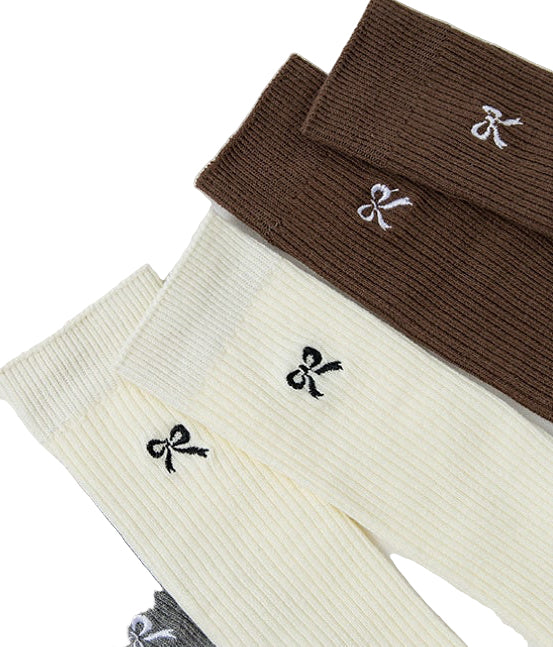 Three pairs of socks in brown, beige, and gray with bow designs on a light gray background.