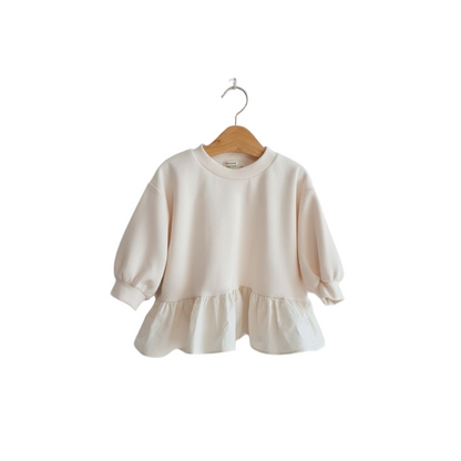 Beige sweater with ruffled hem on a wooden hanger against a white background